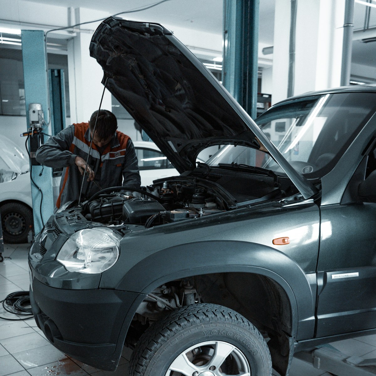 Motor bölmesinde bakım yapan otomotiv teknisyeni